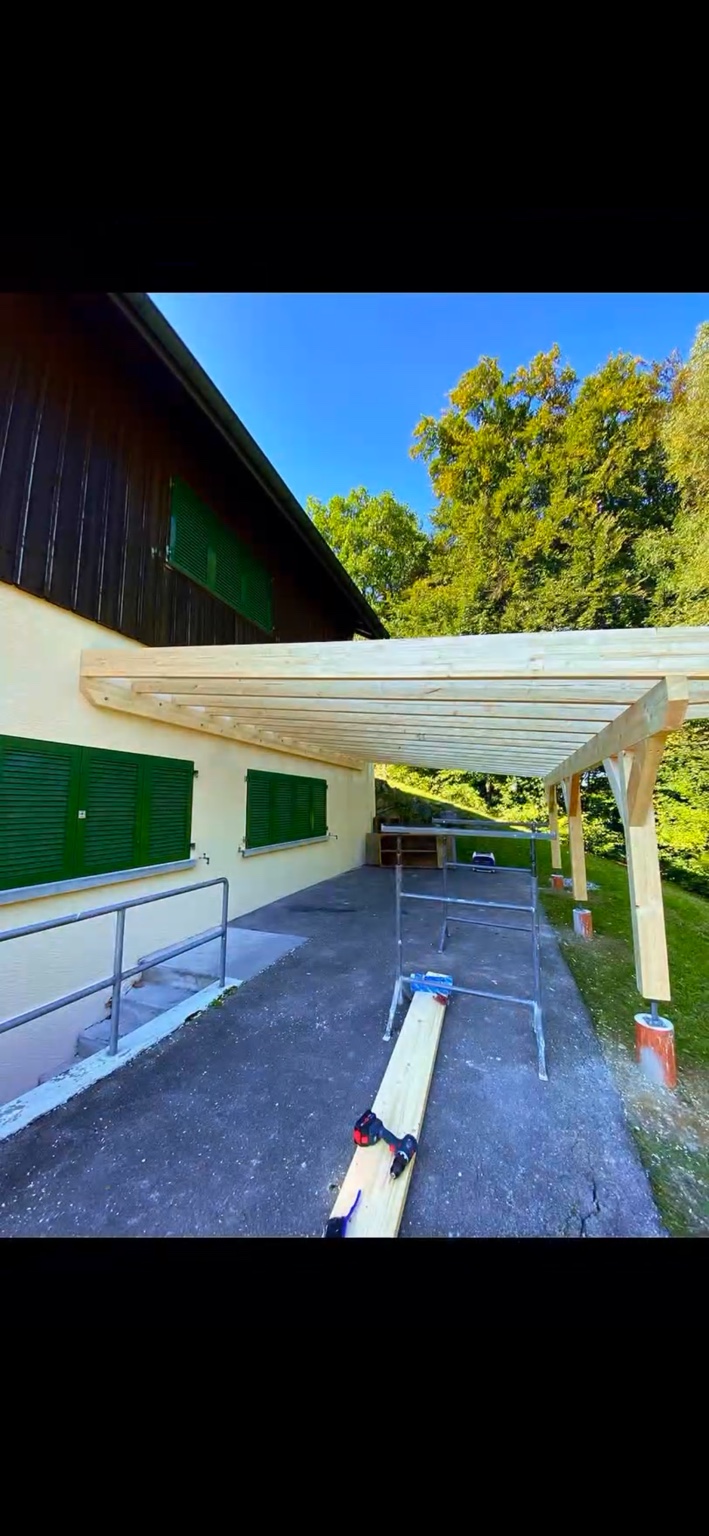 Struttura di una pergola in legno realizzata su misura accanto a un'abitazione