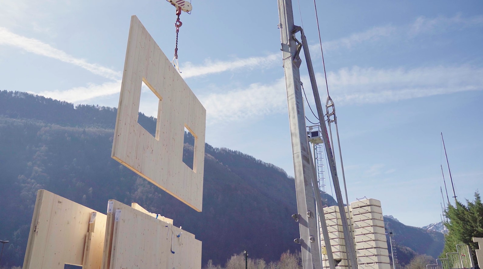 Posa con gru di una parete prefabbricata in legno X-Lam con due aperture per finestre